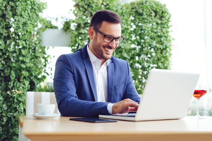 Executivo utilizando software de gestão para analisar relatórios financeiros e de tempo em laptop.