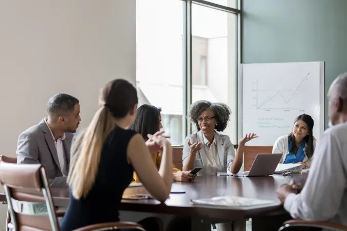Reunião de equipe corporativa discutindo indicadores financeiros e gráficos de margem líquida
