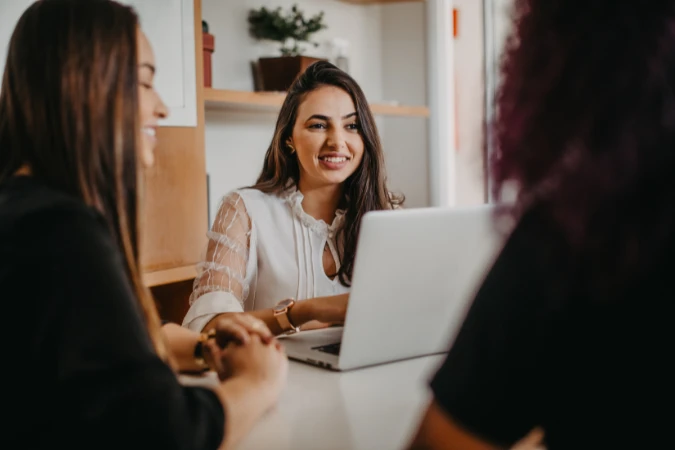 Equipe utilizando software de gestão para organizar briefing e tarefas criativas no FlowUp