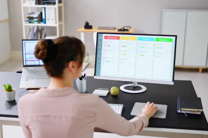 Profissional utilizando software de gestão para acompanhar tarefas em tempo real no computador.