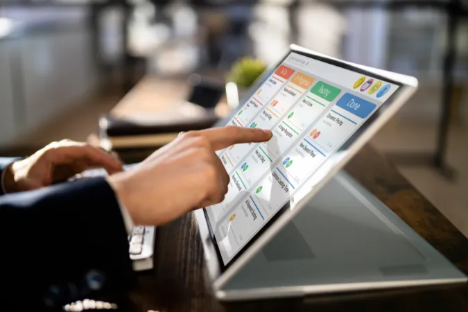 Profissional utilizando software de gestão em tablet para organizar backlog e tarefas no método Scrum