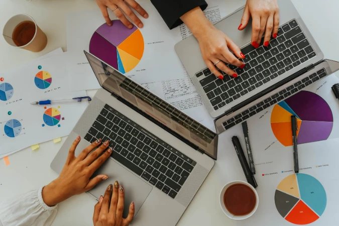 Equipe utilizando gráficos e laptops para planejar ações de gestão financeira estratégica.