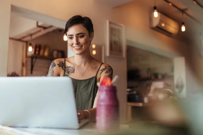 Mulher em home office utilizando notebook para organizar tarefas em um projeto Scrum