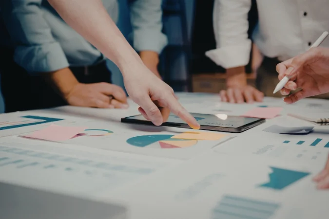 Profissionais analisando gráficos e indicadores para definir o escopo do projeto