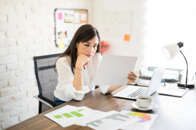 Profissional analisando relatórios financeiros em escritório, representando o gerenciamento de custos em projetos com o guia PMBOK.