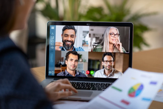 Colaboradores conectados por videoconferência analisando dados e relatórios em tempo real.