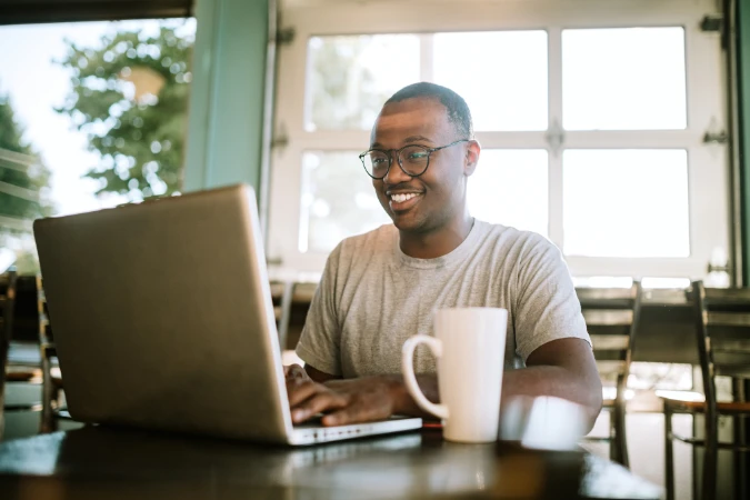 Colaborador remoto utilizando notebook para organizar atividades de um time híbrido com apoio de software de gestão.