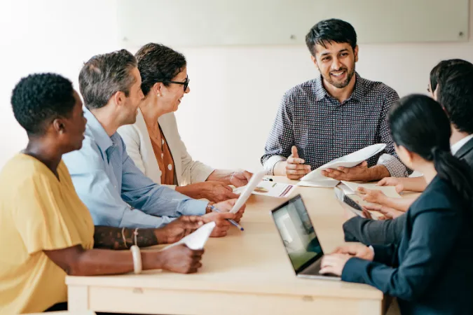 Profissionais discutindo estratégias em grupo, aplicando soft skills para melhorar colaboração e produtividade.