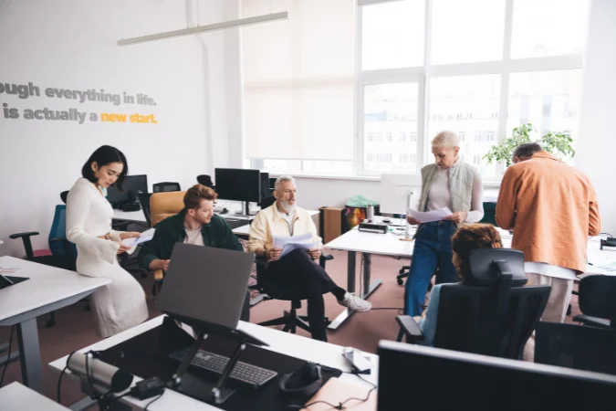 Equipe reunida analisando briefing e discutindo direcionamentos do projeto em conjunto