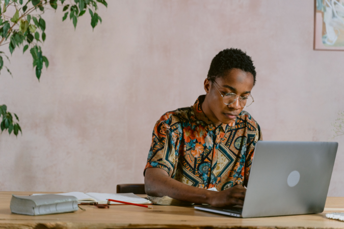 Profissional concentrado estudando com notebook, livros e anotações sobre a mesa