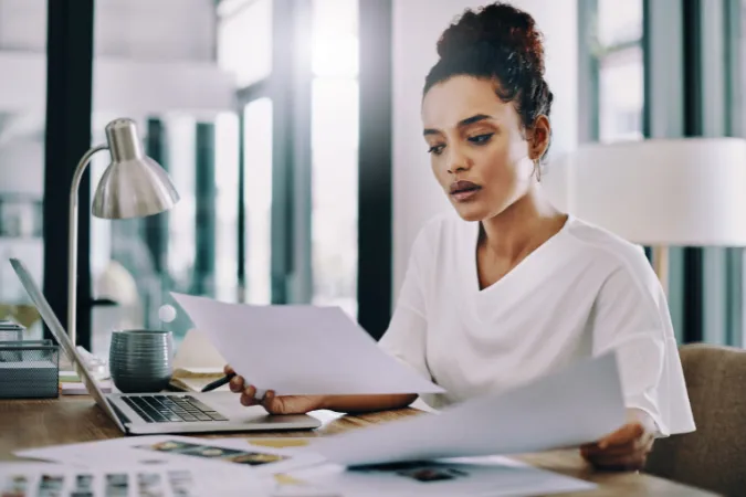 Profissional analisando documentos para prevenir retrabalho e garantir qualidade na entrega