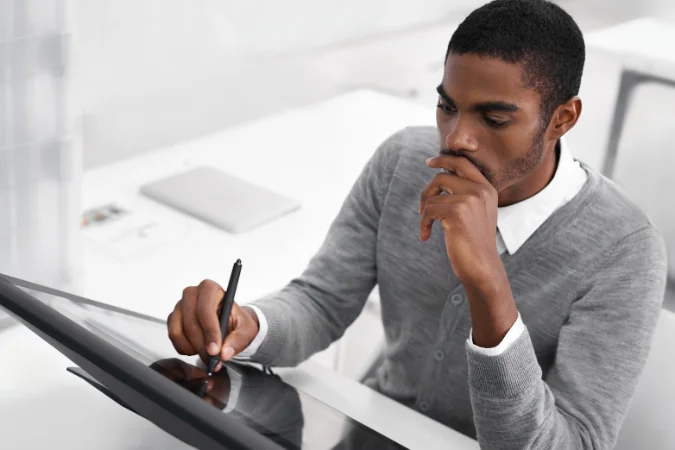 Profissional trabalha concentrado em mesa digitalizadora; sessão de deep work aplicada à Autogestão.