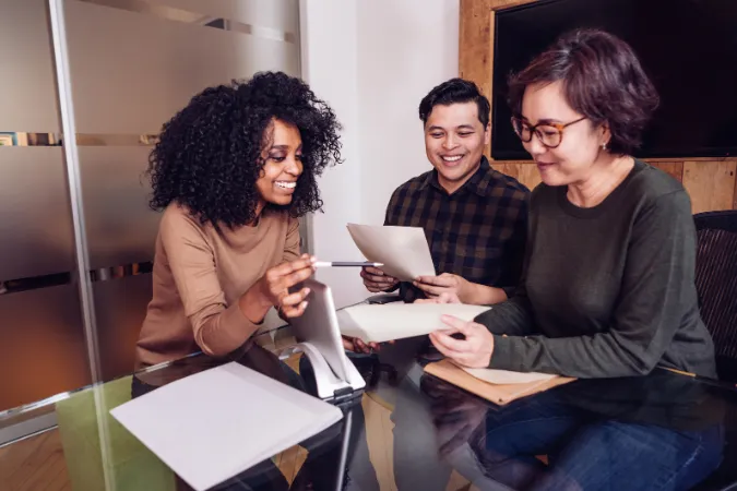 Grupo de profissionais praticando a Power Skill de colaboração em uma reunião com foco em projetos.