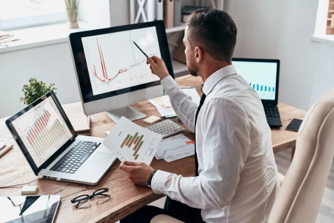 Profissional analisando relatórios em múltiplas telas, simbolizando a importância do deep work em tarefas analíticas e estratégicas.