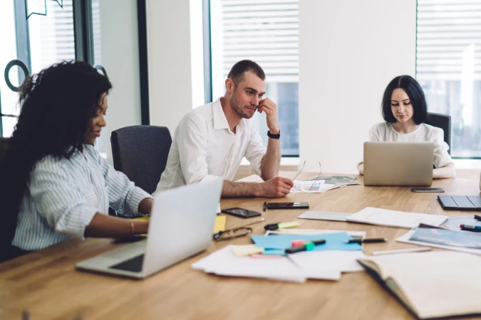 Equipe de profissionais trabalhando concentrada em conjunto em uma mesa de escritório, representando o deep work em grupo.