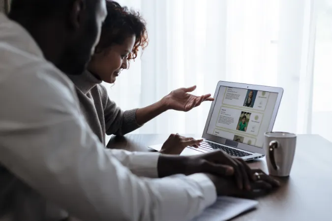Dois profissionais analisam informações em um notebook para apoiar a tomada de decisão.