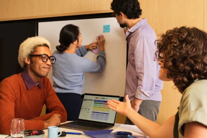 Equipe reunida analisando planejamento financeiro em notebook durante reunião