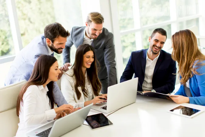 Profissionais de negócios reunidos com notebooks e relatórios em ambiente corporativo