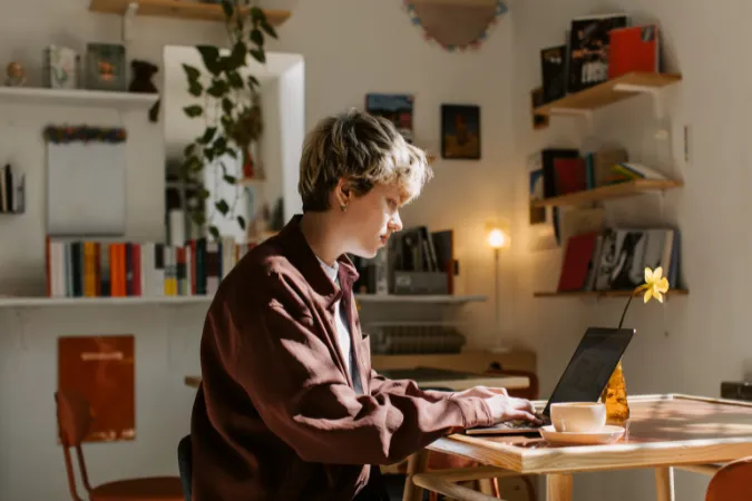 Pessoa concentrada trabalhando em laptop em um ambiente organizado, representando o estado de flow no trabalho apoiado por software de gestão.