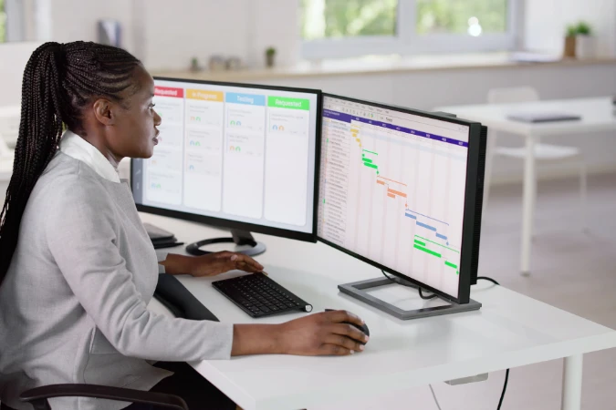 Profissional acompanhando tarefas em gráficos Gantt e quadros Kanban na tela, representando o uso do FlowUp para gestão de tempo.