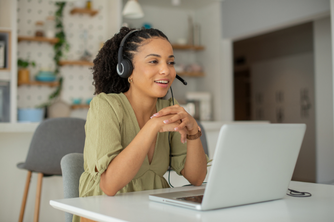 Profissional atendendo cliente em videoconferência usando um script de vendas para conduzir a conversa.