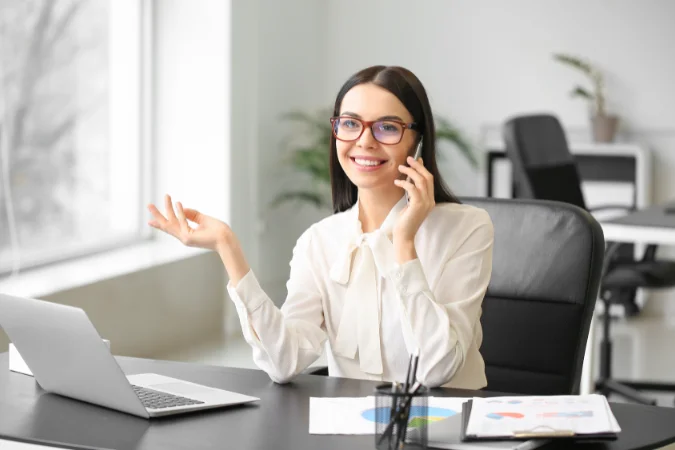 Profissional usando notebook e telefone em ambiente corporativo organizado com apoio de software de gestão