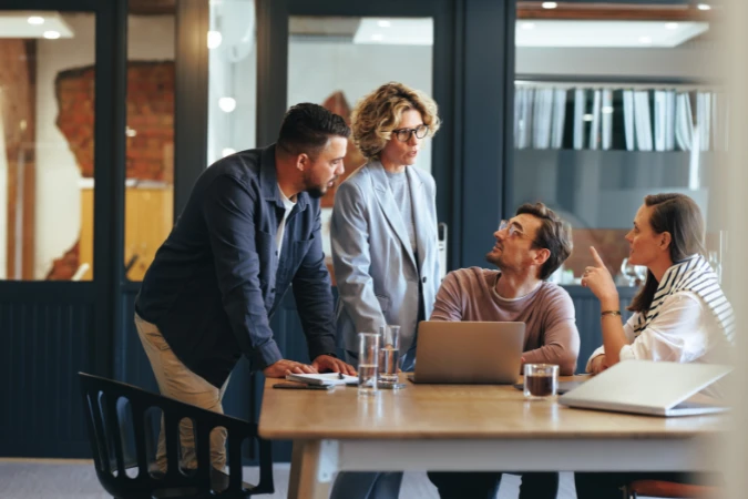 Equipe reunida em mesa discutindo decisões estratégicas em um ambiente corporativo, aplicando princípios de transformação ágil