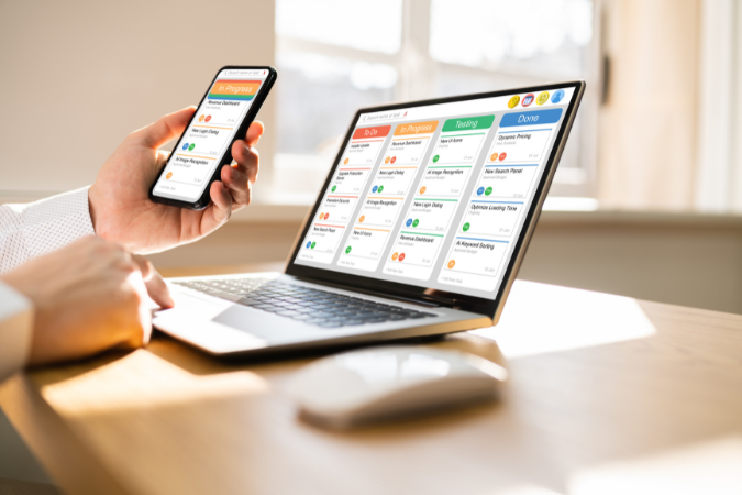 Tela de computador e celular exibindo quadro Kanban digital com tarefas organizadas por status