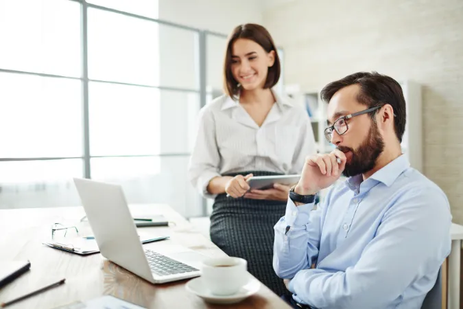 Equipe reunida em frente ao computador discutindo insights gerados por ferramentas de IA aplicadas à gestão de pessoas.