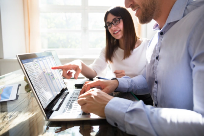 Profissionais analisando o Diagrama de Gantt em um notebook para organizar prazos e tarefas de um projeto
