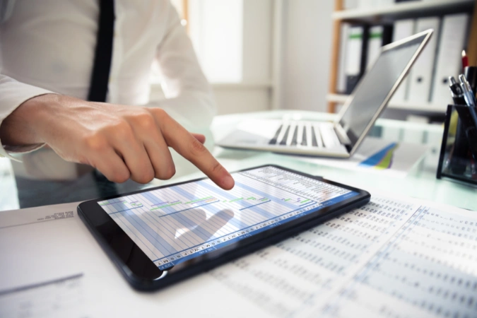 Profissional utilizando o Diagrama de Gantt em um tablet para acompanhar o cronograma de um projeto em tempo real