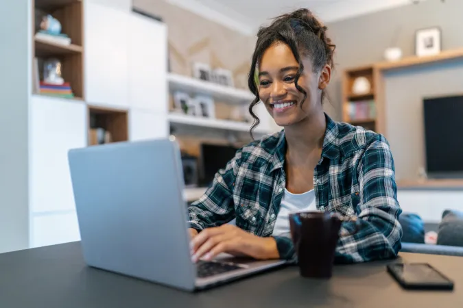 Mulher trabalhando em um software de gestão no notebook para organizar tarefas e acompanhar projetos com mais eficiência.