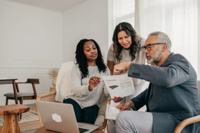 Grupo de profissionais em reunião, analisando relatórios e estratégias em ambiente colaborativo.