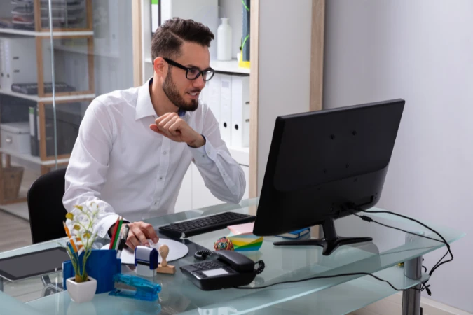 Profissional observando gráficos e dados de projetos no computador para tomada de decisão.
