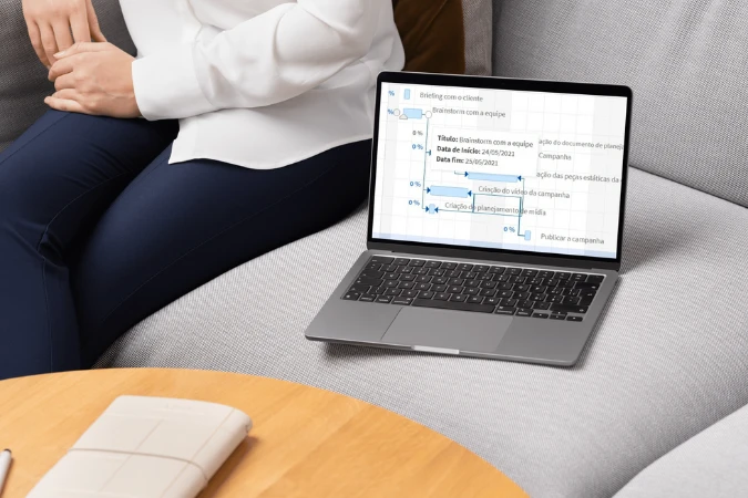 Cronograma de projeto aberto em um notebook exibindo tarefas e dependências no formato de Diagrama de Gantt.