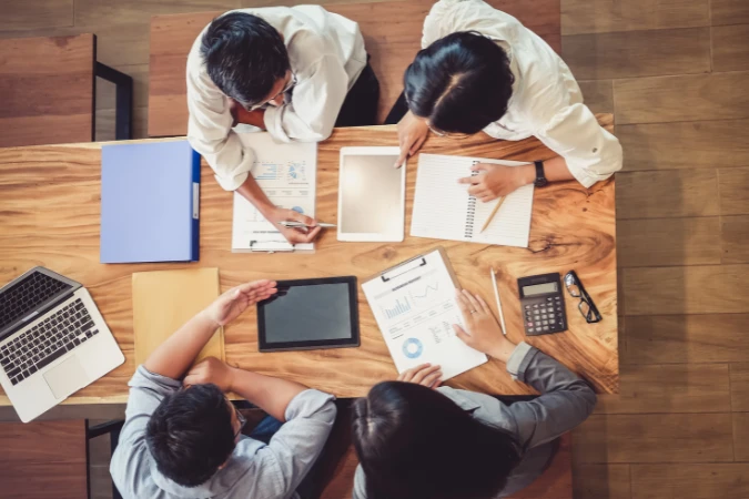 Equipe colaborativa utilizando relatórios e dispositivos digitais para gerenciar projetos com Canvas