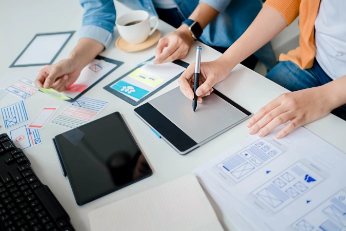 Designers e desenvolvedores organizam protótipos e fluxos visuais, aplicando o método 5W2H para validar hipóteses e priorizar funcionalidades.