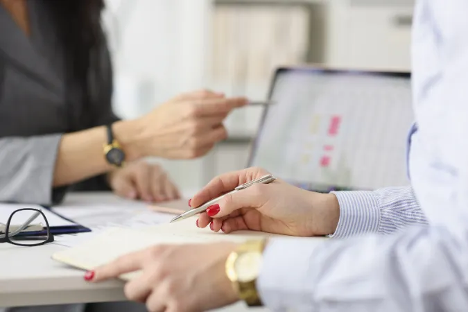 Grupo de líderes e profissionais discutindo estratégias e métodos para delegação de tarefas em equipes multidisciplinares.