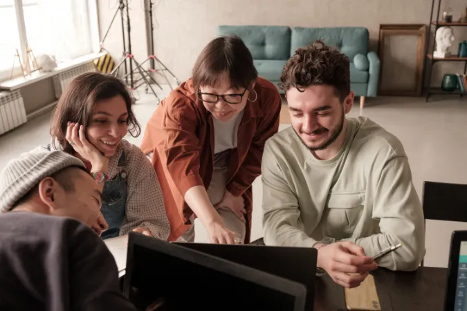 Equipe multidisciplinar alinhando atividades em software de gestão de tarefas para colaboração eficiente