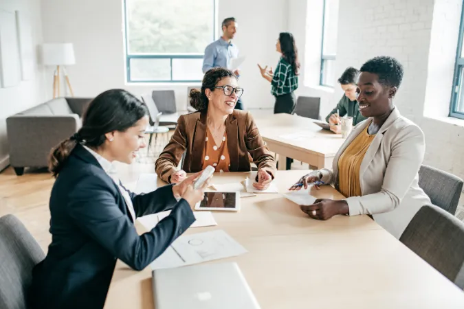 Profissionais em reunião discutindo tarefas, decisões e alinhamentos de projeto em um ambiente colaborativo.