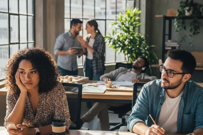 Profissionais em um escritório mostrando falta de demanda e tempo ocioso devido a gargalos no fluxo de trabalho.