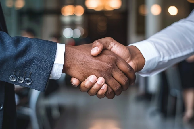Aperto de mãos simbolizando fechamento de negócio baseado no playbook de vendas para serviços