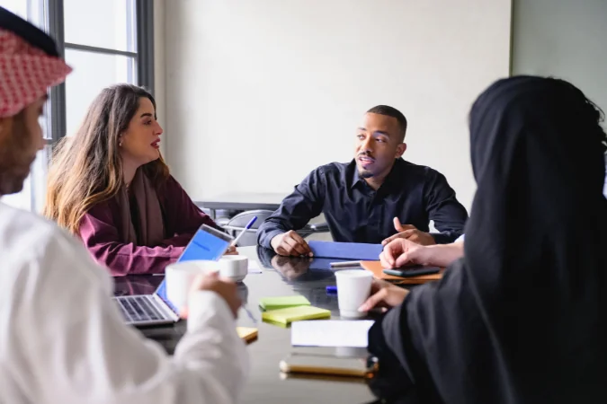 Equipe em reunião discutindo dependências entre tarefas e alinhando decisões do projeto