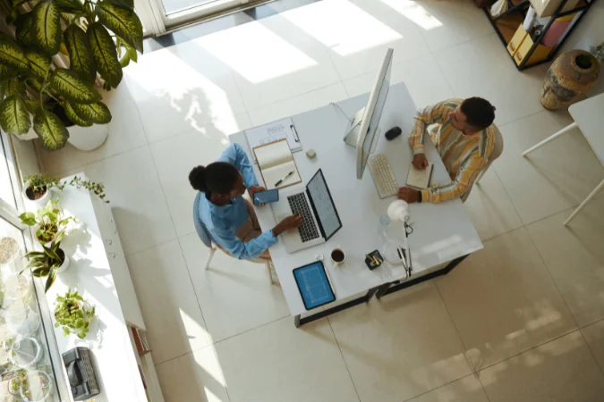 Vista superior de equipe trabalhando em conjunto, simbolizando visualização do fluxo e dependências do projeto