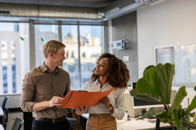 Profissionais analisando documento de projeto e discutindo entregáveis técnicos