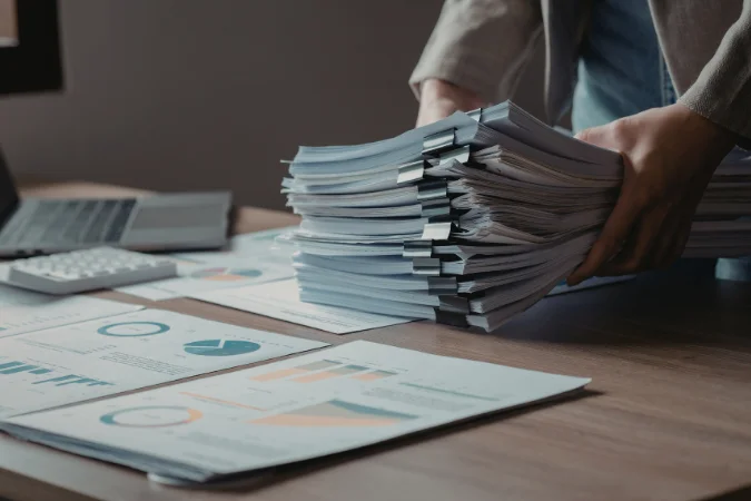 Profissional analisando documentos impressos em ambiente corporativo