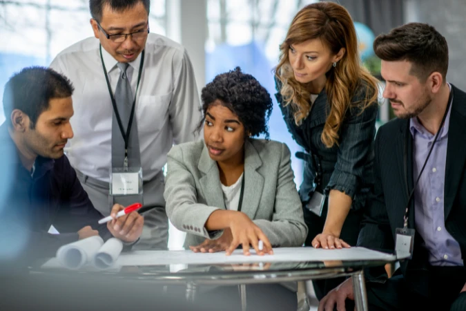 Equipe multidisciplinar discutindo projeto técnico com foco em decisões claras e redução de complexidade