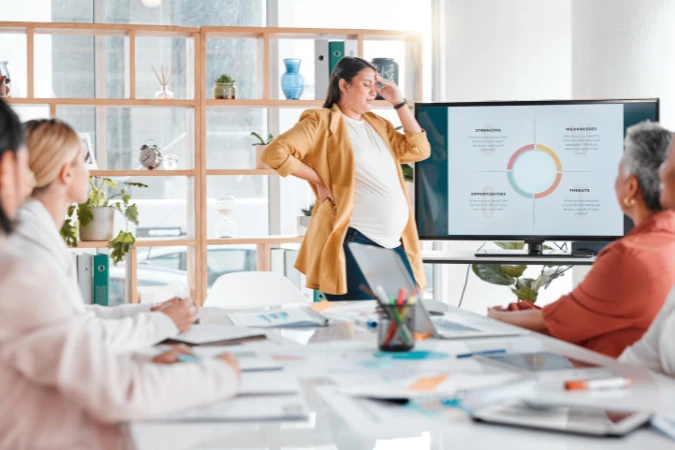 Líder apresentando análise SWOT em reunião com equipe e gráfico exibido em tela.