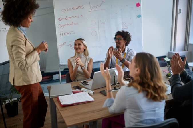 Equipe reunida em sala de reunião analisando matriz SWOT em quadro
