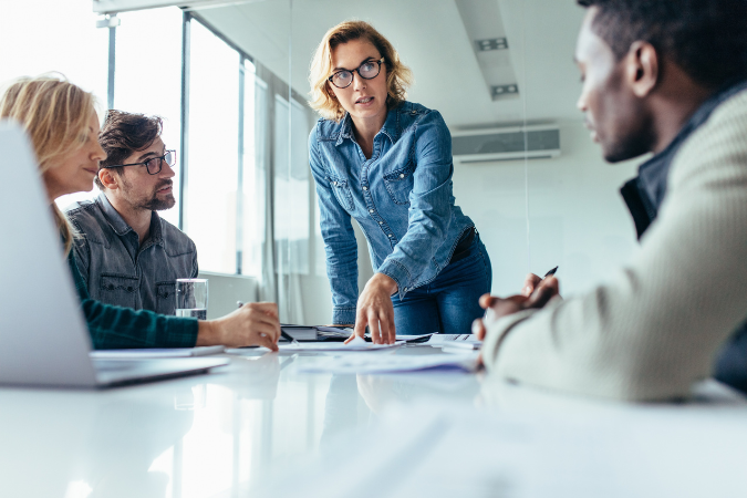 Gestora conduz uma reunião estratégica com equipe diversa, demonstrando como o estilo cognitivo influencia a liderança e a tomada de decisão.